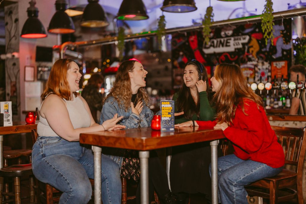 Four women enjoying conversation in a lively Islamabad cafe with colorful decor.